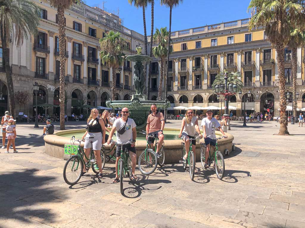 Vriendenparen met kinderen op de fiets in Plaza Real, Barcelona.