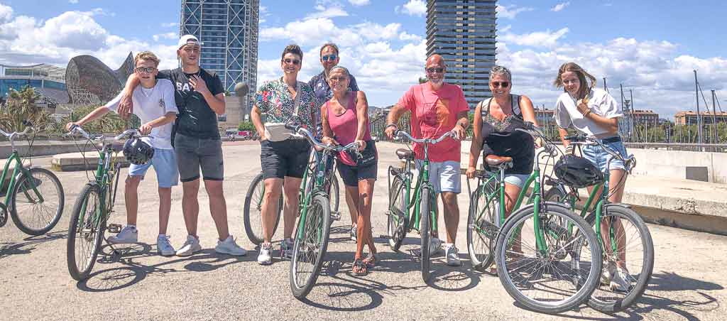 Group of people of all ages enjoying a guided bike tour on a sunny day in Barcelona with an English-speaking guide