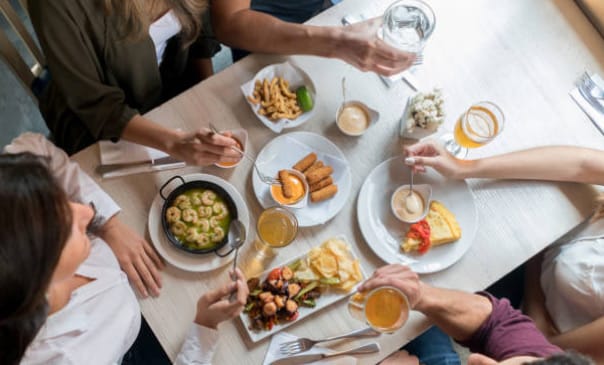 Group of friends sharing tapas plates during Perry Tours' Tapas Bike Tour in Barcelona.