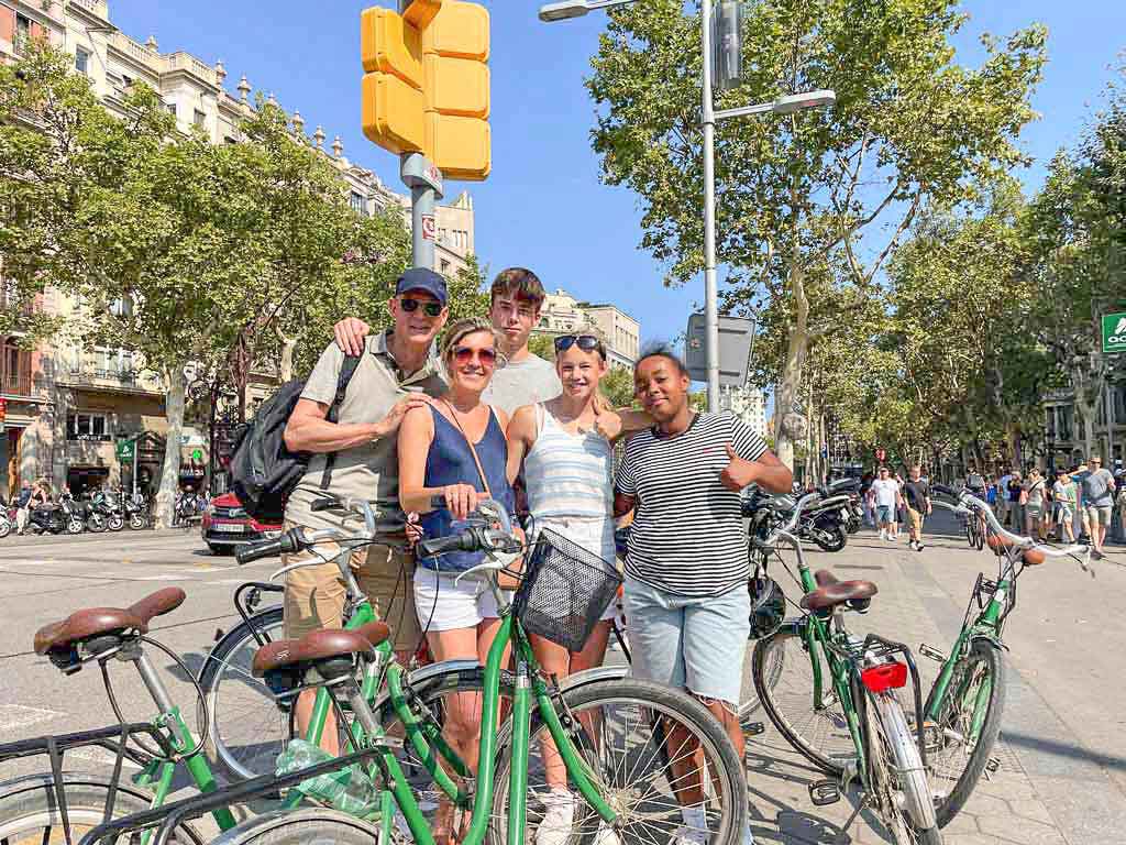 Family with three kids on a family bike tour in Barcelona, having a photo moment at Passeig de Gràcia