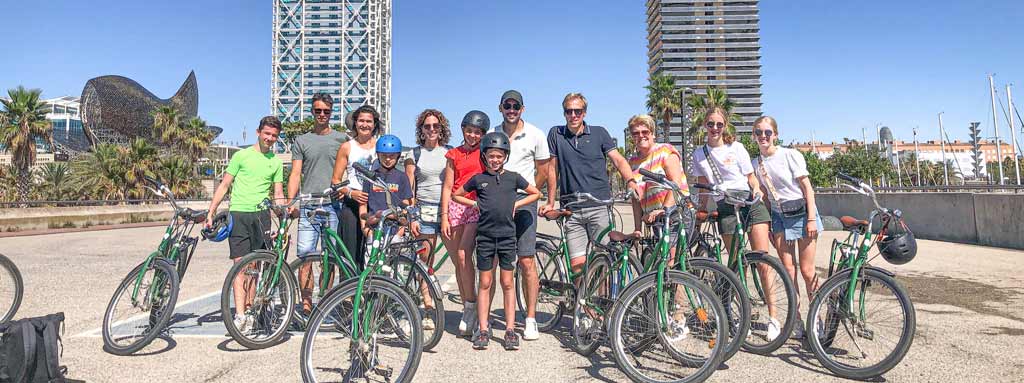 Large family with uncles, aunts, grandparents, parents, and children on a bike tour with Perry Tours, with the Arc de Triomf in Barcelona in the background