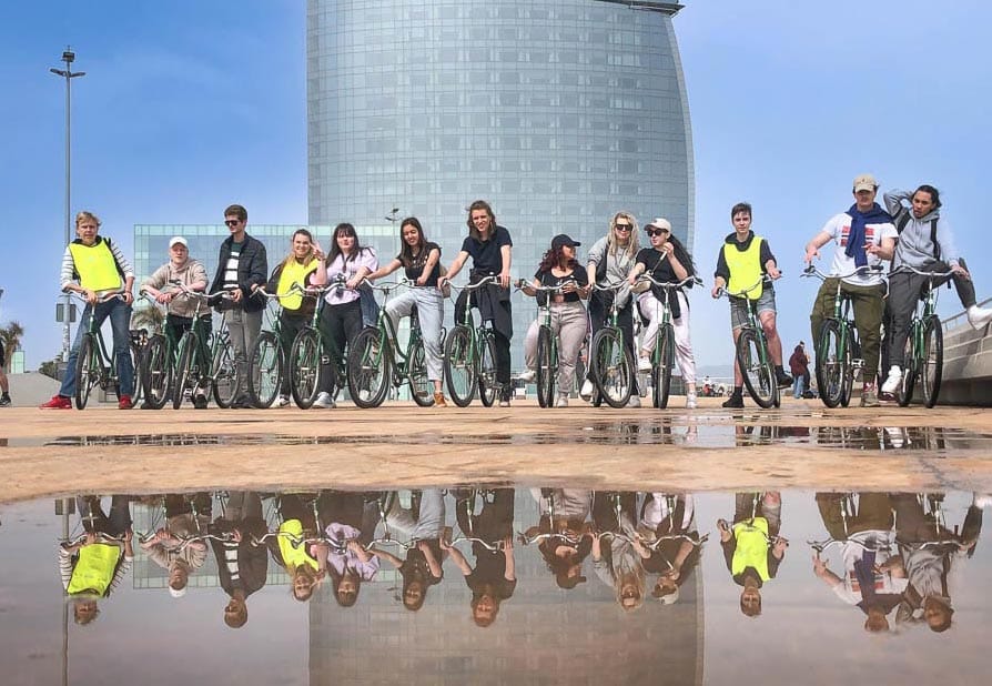 Studenten op fietstour met Perry Tours poseren bij het W Hotel in Barcelona tijdens een studiereis
