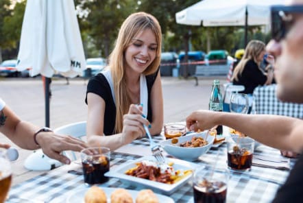 People enjoying authentic tapas at a local bar during the Tapas Bike Tour in Barcelona by Perry Tours.