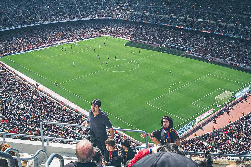 Groepsreis naar Barcelona - Bezoek aan Camp Nou tijdens een voetbalwedstrijd, mensen op de tribunes met voetbalveld op de achtergrond