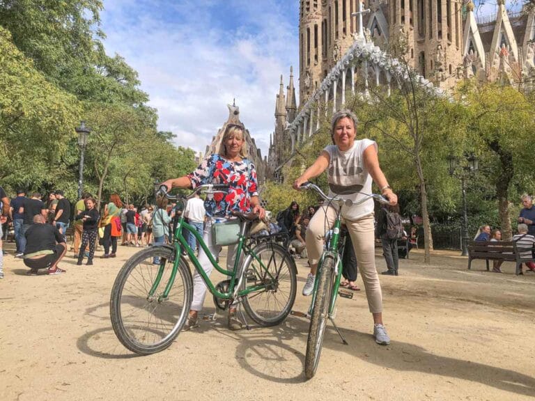 Twee vriendinnen poseren met fietsen voor de Sagrada Família tijdens een privé fietstocht met Perry Tours in Barcelona.